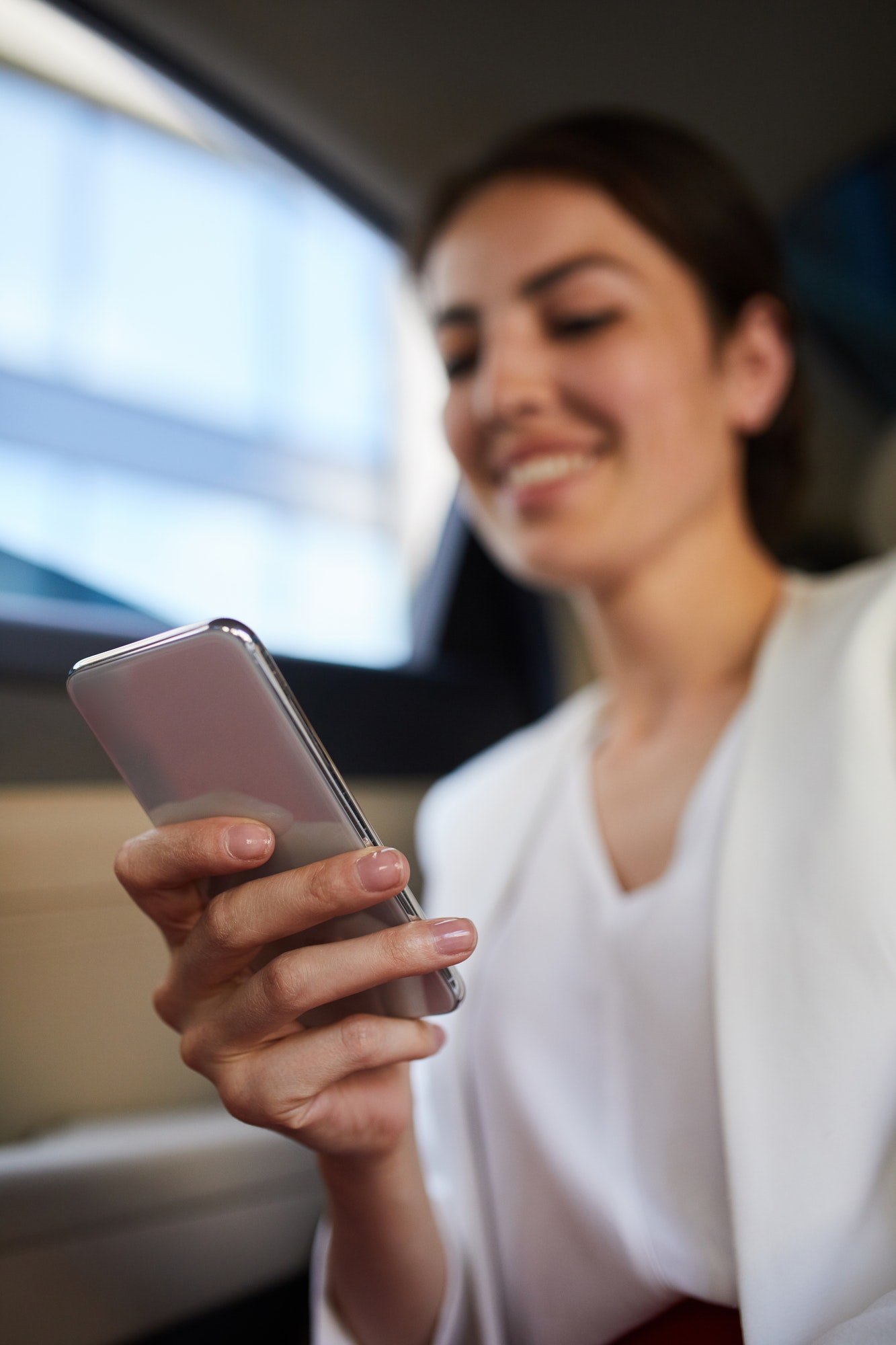 Smiling Woman Using Smartphone in Car